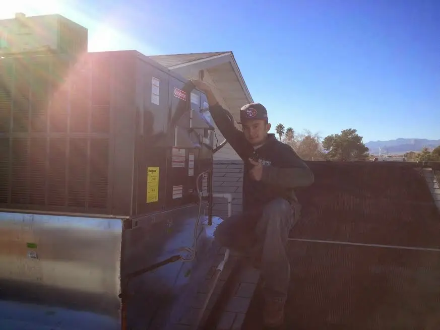 HVAC technician performing AC Tune-Up on a rooftop unit in Loma Linda
